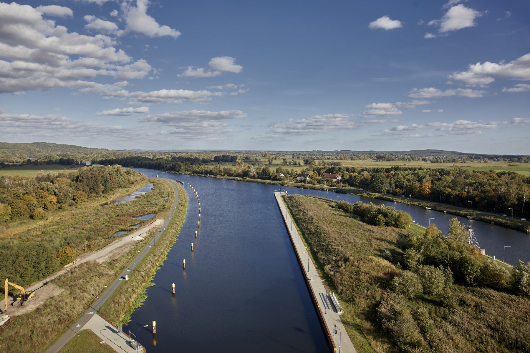 Der Kanal zieht sich schnurgerade durch die Landschaft, am Ufer Wiesen und Wald
