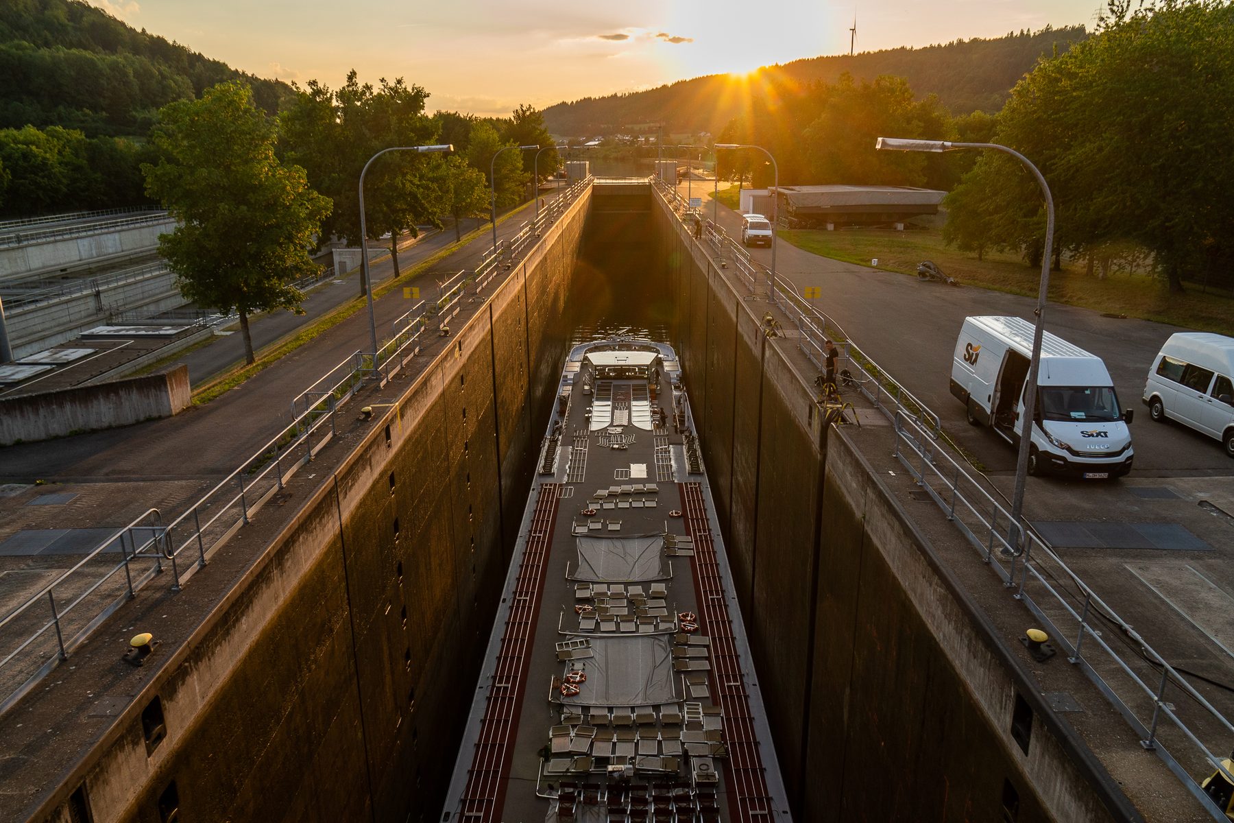 Das Schiff liegt in der tiefen Schleusenkammer von Dietfurt im Abendlicht, oben am Rand die Straße