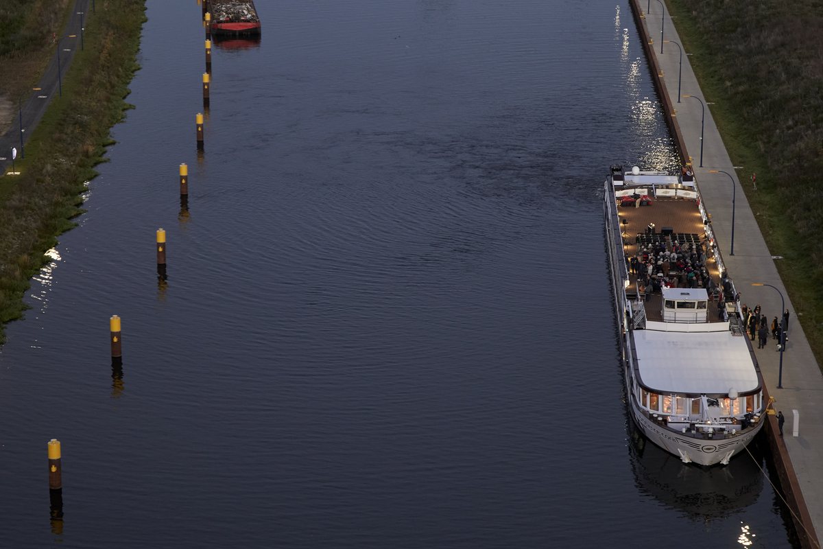 Das voll besetzte Konzertschiff am Kanalufer in der Abenddämmerung, von oben gesehen