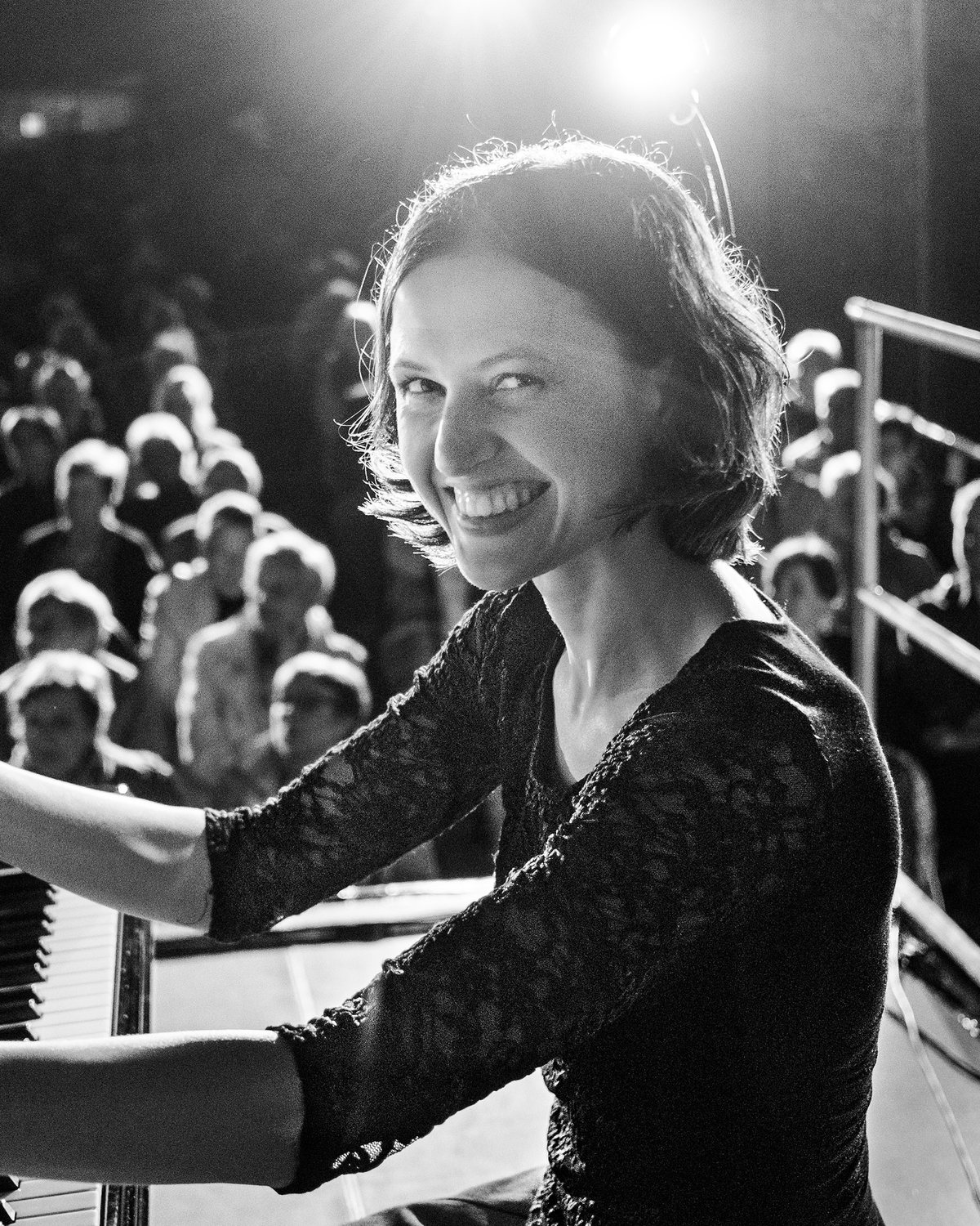 Alina Pronina lacht vom Flügel in die Kamera, hinter ihr das voll besetzte Deck