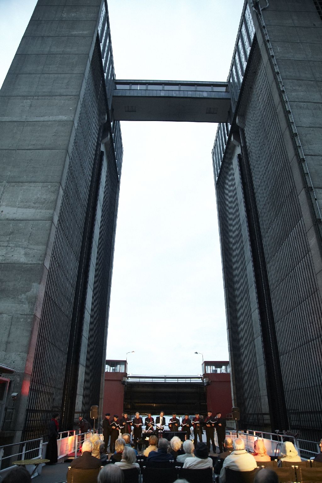 Chor am Bug vor dem Trogtor zwischen den Betontürmen des Schiffshebewerks Scharnebeck, davor Publikum